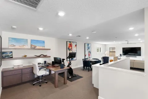 a living room with furniture kitchen view and a flat screen tv