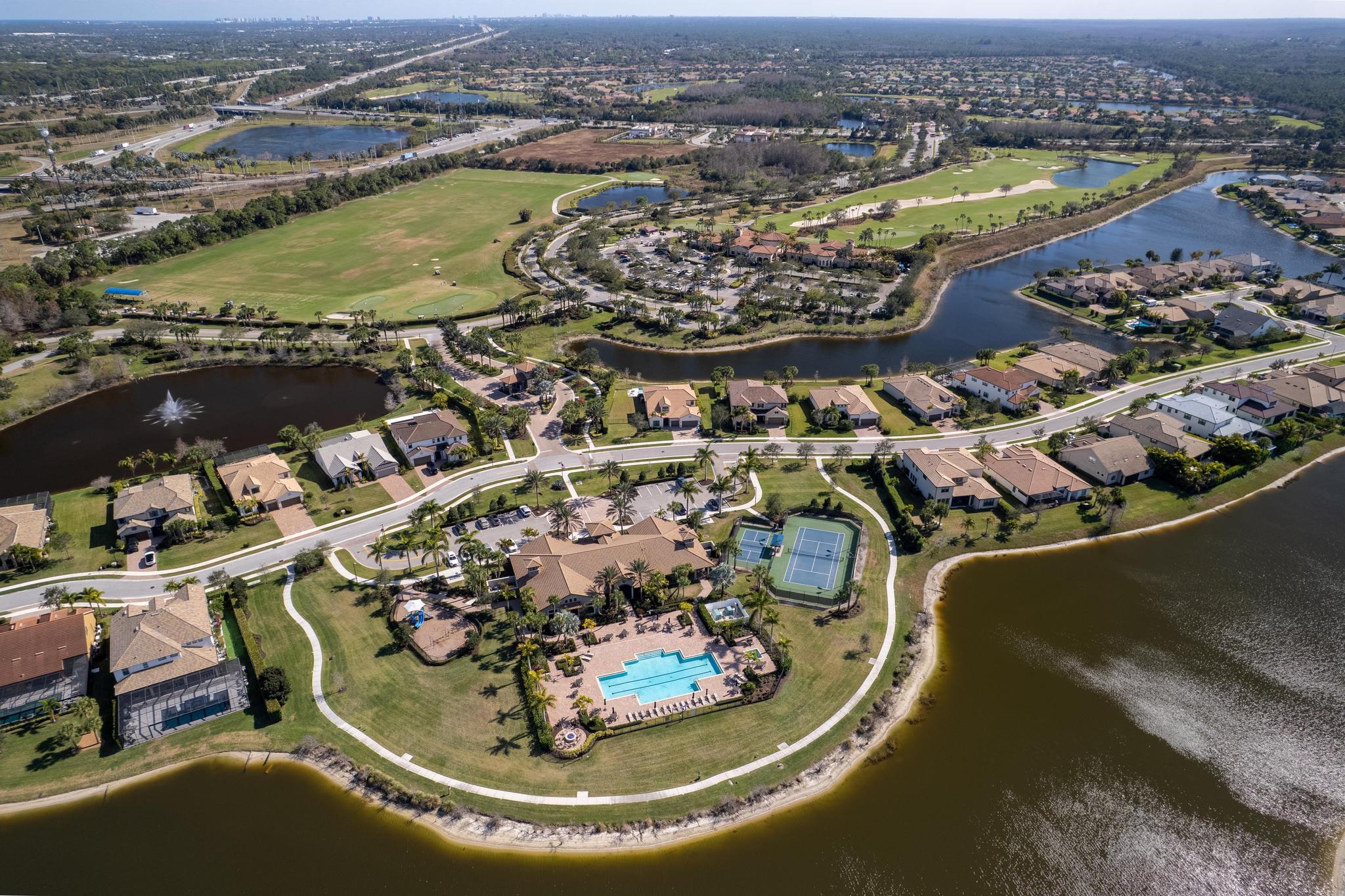 137 Cinder Dunes Point Jupiter, FL 33478 - Photo 44 of 45 an aerial view of a house with a swimming pool lake and mountain view in back