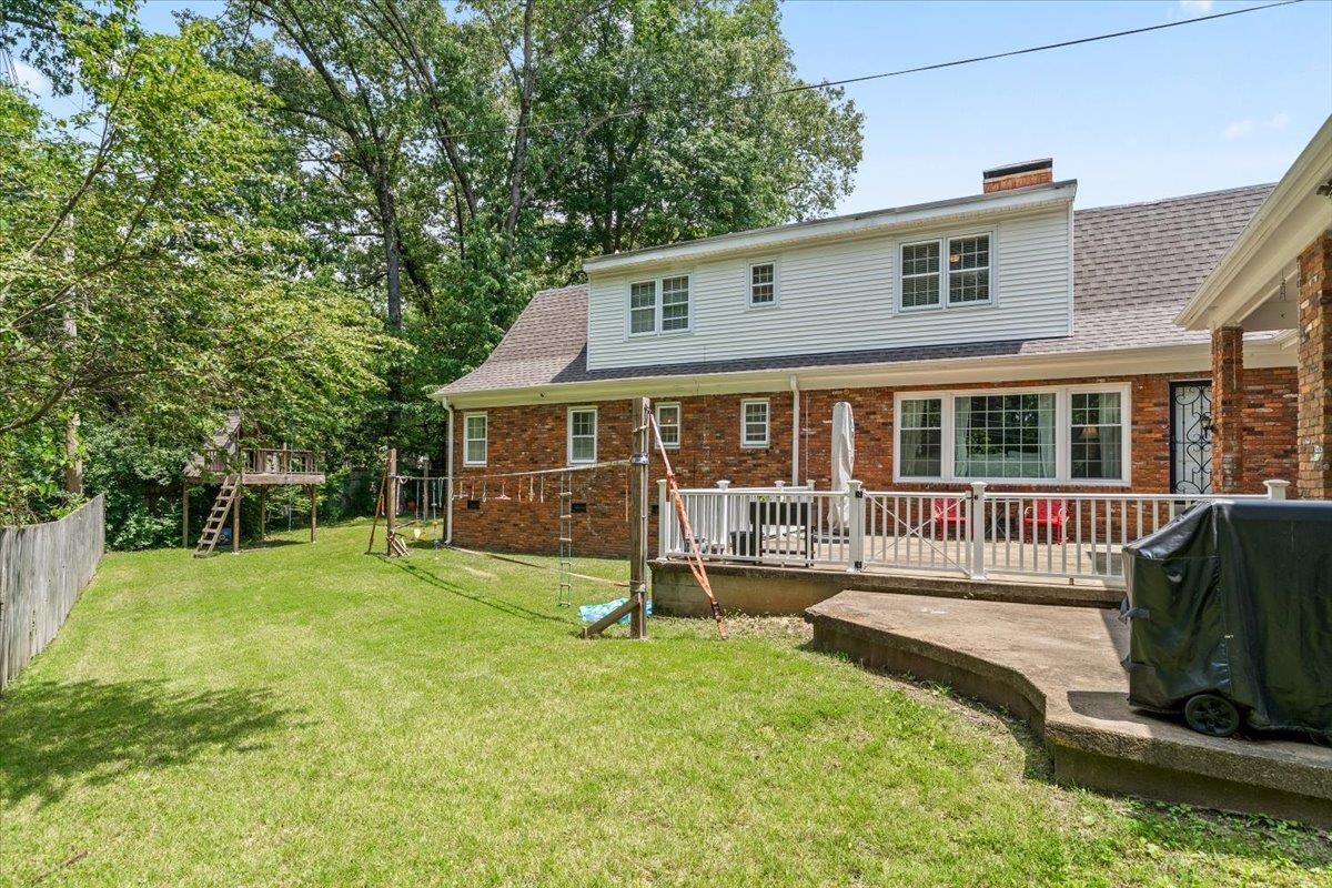 1273 Brookfield Road Memphis, TN 38119 - Photo 35 of 40 Expansive backyard featuring a manicured lawn, a raised wooden playhouse, and mature trees