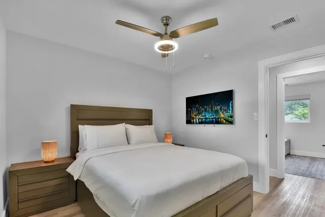 a bedroom with a large bed and a chandelier