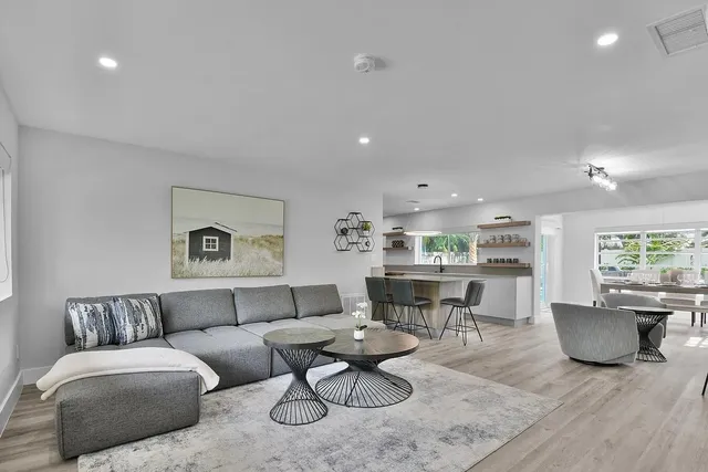a living room with furniture a rug and kitchen view