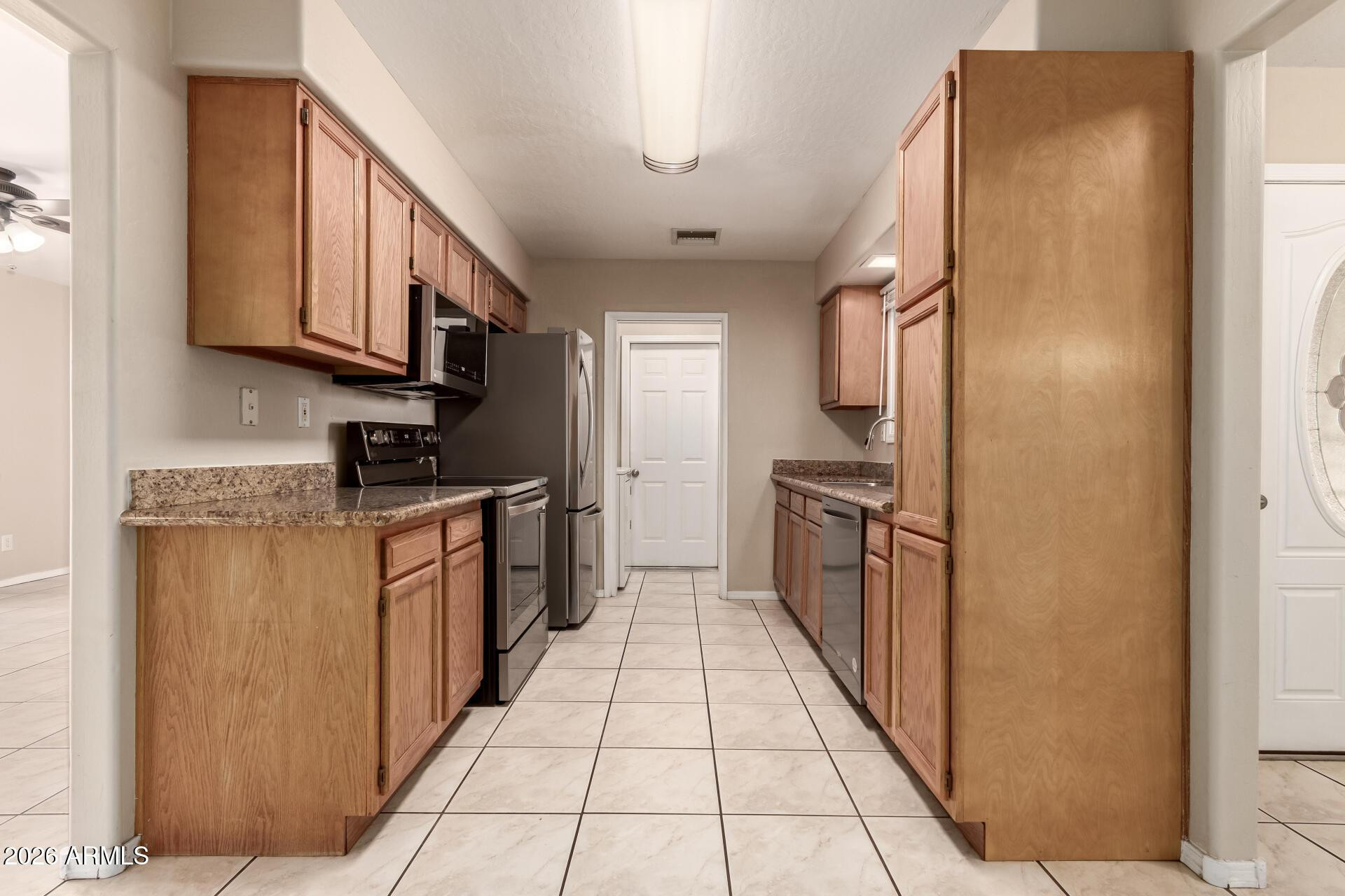 3613 South Kenneth Place Tempe, AZ 85282 - Photo 8 of 17 a kitchen with stainless steel appliances granite countertop a refrigerator and a stove