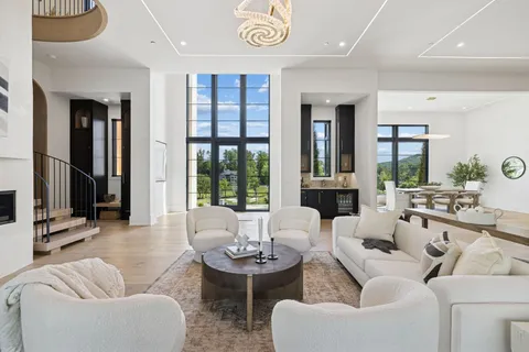 a kitchen with stainless steel appliances granite countertop a table chairs in it and wooden floors
