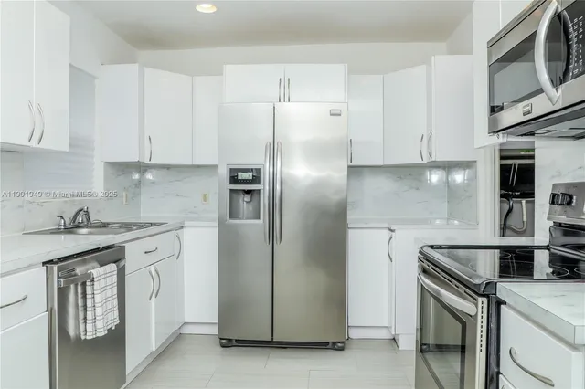 a kitchen with stainless steel appliances granite countertop a stove a refrigerator and a sink
