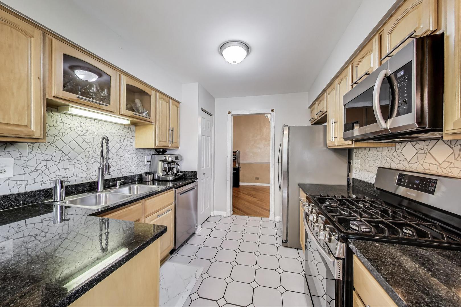 738 Hapsfield Lane, Unit 7A2 Buffalo Grove, IL 60089 - Photo 12 of 29 a kitchen with stainless steel appliances granite countertop a stove and a microwave