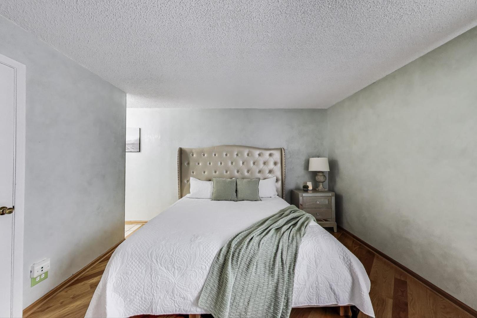 738 Hapsfield Lane, Unit 7A2 Buffalo Grove, IL 60089 - Photo 17 of 29 a bedroom with a bed and a night stand