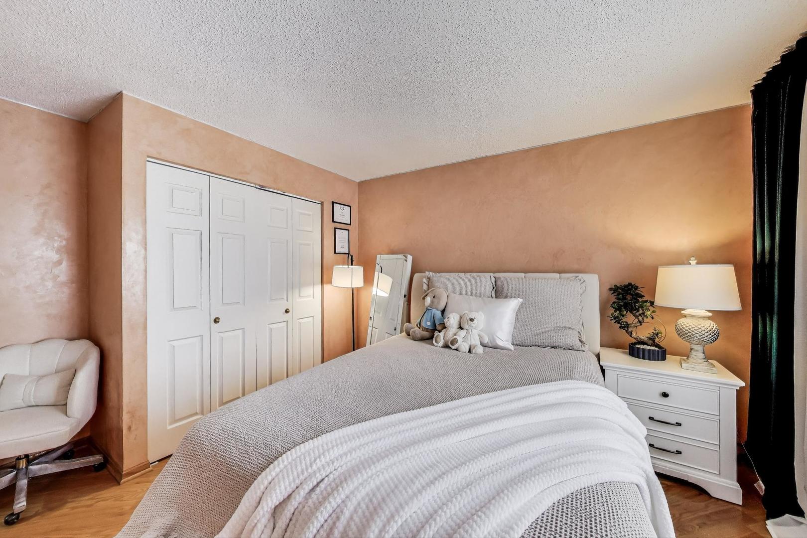 738 Hapsfield Lane, Unit 7A2 Buffalo Grove, IL 60089 - Photo 21 of 29 a bedroom with a bed a chair and painting on the wall