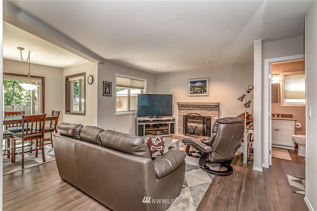 3126 210th Street Southeast Bothell, WA 98021 - Photo 11 of 33 a living room with furniture a fireplace and a flat screen tv