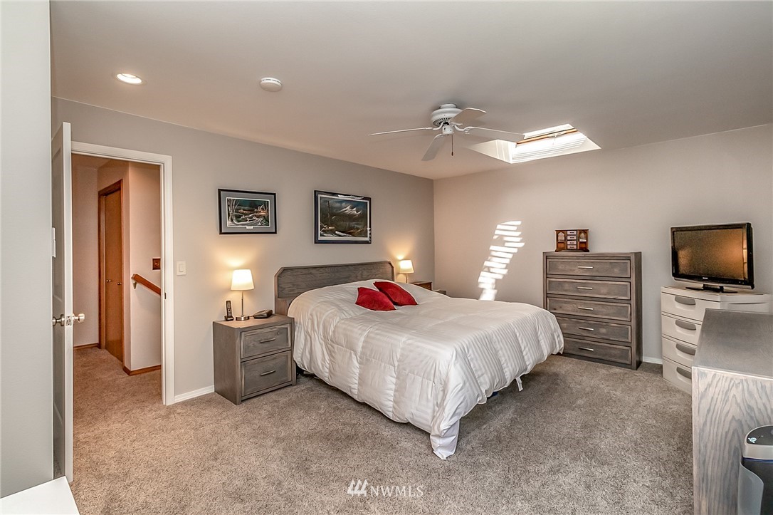 3126 210th Street Southeast Bothell, WA 98021 - Photo 16 of 33 a bedroom with a bed and a chandelier