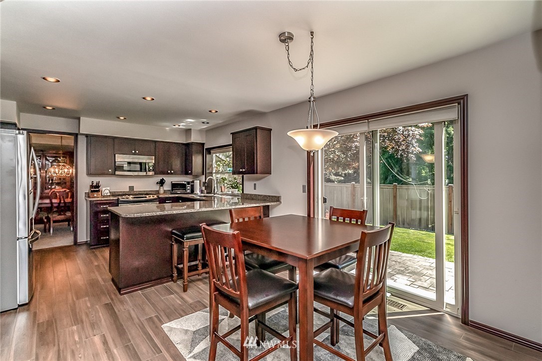 3126 210th Street Southeast Bothell, WA 98021 - Photo 9 of 33 a dining room with stainless steel appliances granite countertop a table chairs and a wooden floor