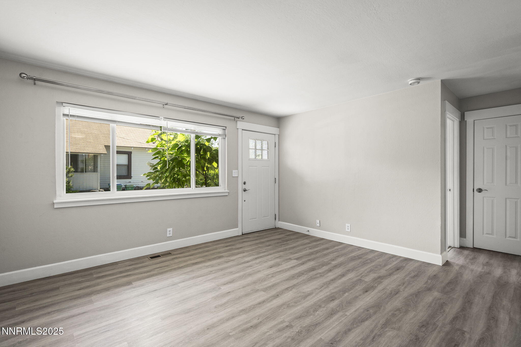 1227 Gordon Avenue Reno, NV 89509 - Photo 7 of 22 a view of an empty room with wooden floor and a window