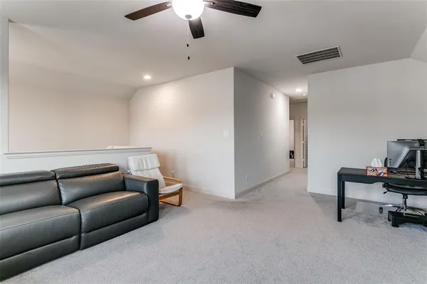 a living room with furniture and a ceiling fan
