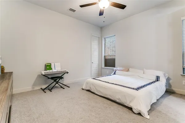 a spacious bedroom with a bed and a chandelier