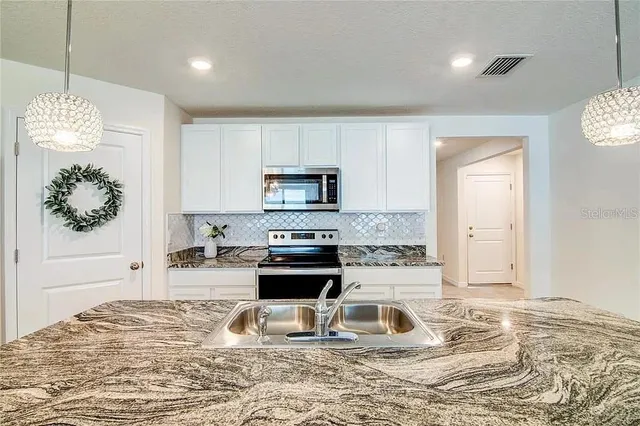 a kitchen with a stove a sink and a refrigerator