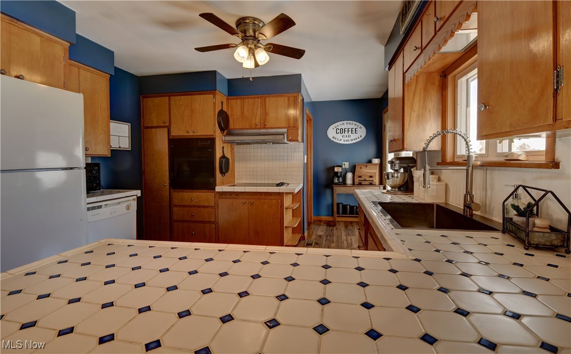 15235 Stocker Ridge Road Southwest Newcomerstown, OH 43832 - Photo 21 of 37 Kitchen featuring tile countertops, ceiling fan, sink, and white appliances