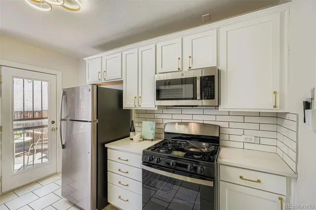 a kitchen with stainless steel appliances white cabinets and a stove top oven