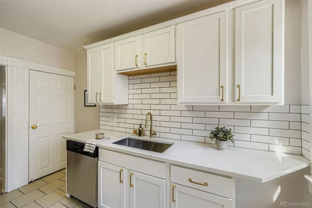 a kitchen with stainless steel appliances white cabinets and a sink