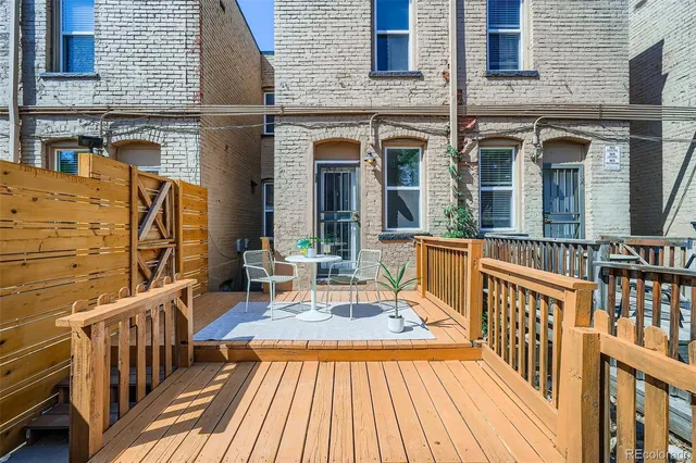 a view of a brick house with a wooden deck
