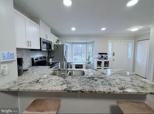 a kitchen with stainless steel appliances granite countertop a sink stove and refrigerator