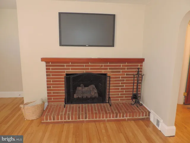 a living room with a fireplace wooden floor and furniture