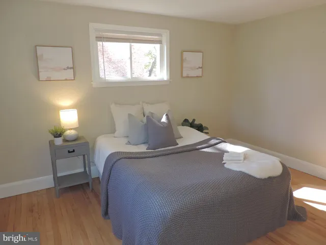 a bed sitting in a bedroom next to a window