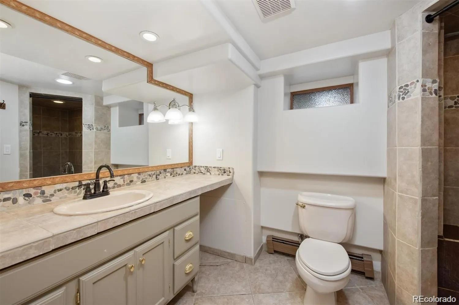 3201 Stuart Street Denver, CO 80212 - Photo 13 of 25 a bathroom with a toilet sink and mirror