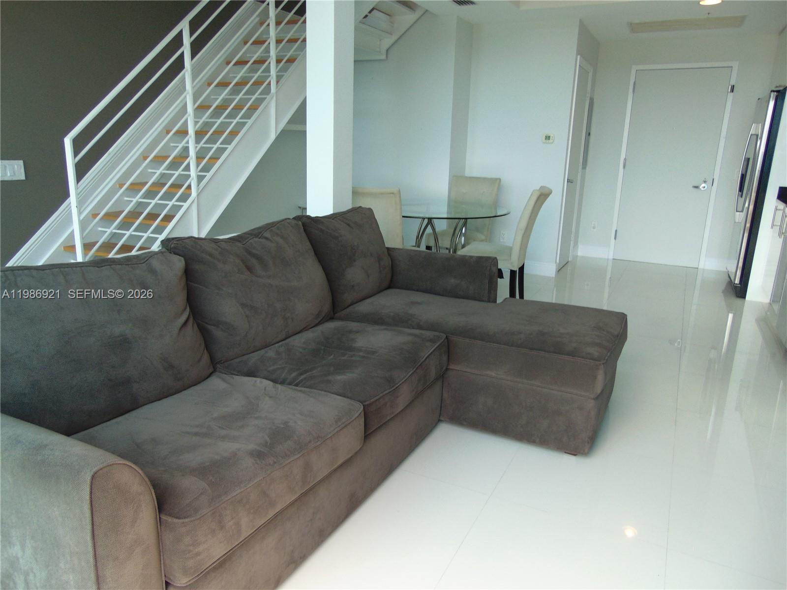 60 Southwest 13th Street, Unit 2619 Miami, FL 33130 - Photo 14 of 27 a living room with furniture and a window