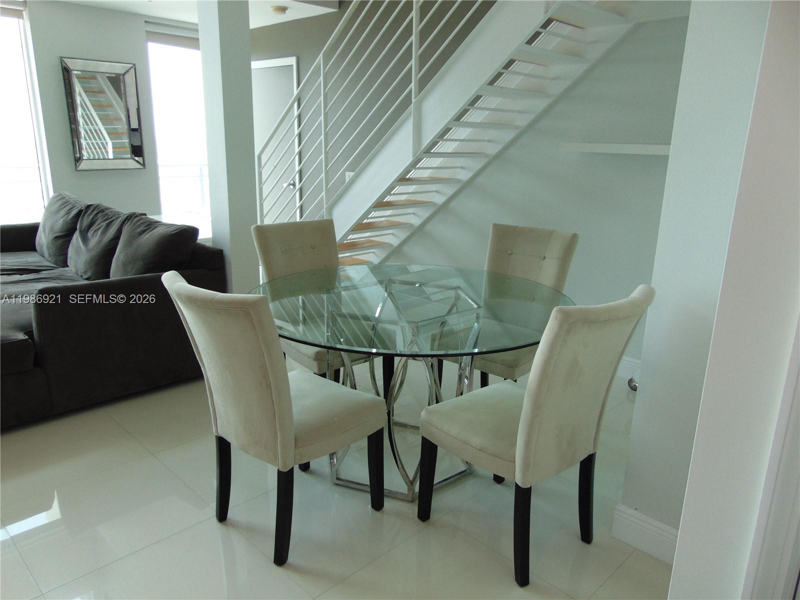 60 Southwest 13th Street, Unit 2619 Miami, FL 33130 - Photo 15 of 27 a view of a dining room with furniture and wooden floor