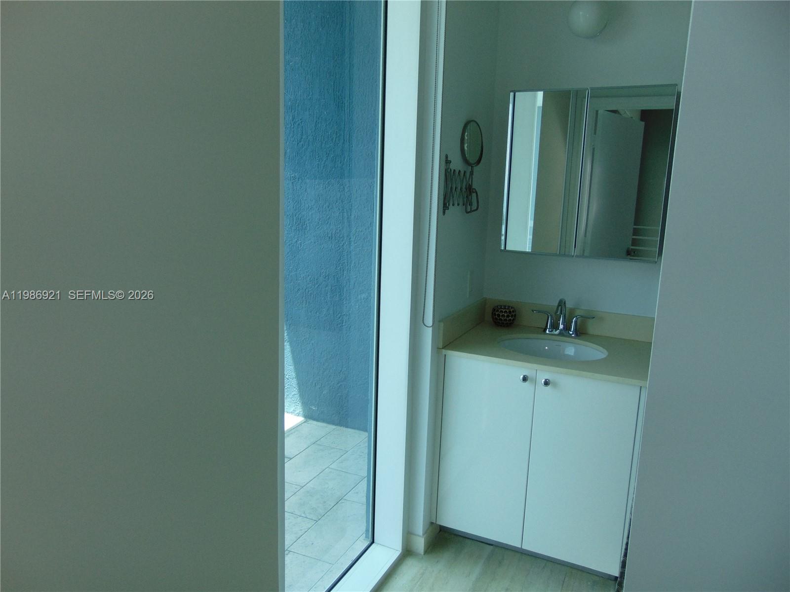 60 Southwest 13th Street, Unit 2619 Miami, FL 33130 - Photo 18 of 27 a bathroom with a sink and mirror
