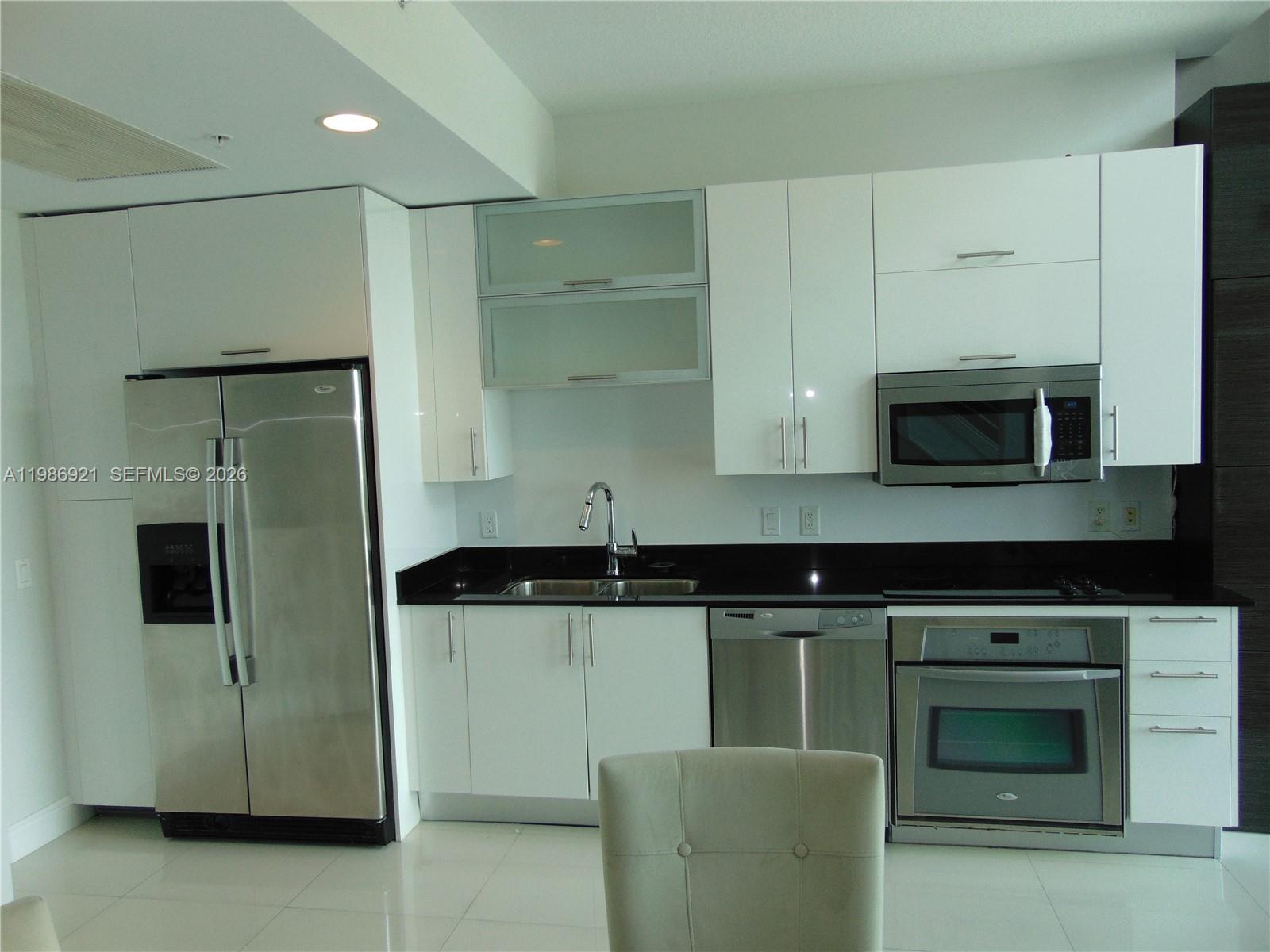 60 Southwest 13th Street, Unit 2619 Miami, FL 33130 - Photo 9 of 27 a kitchen with stainless steel appliances granite countertop a stove a microwave and a refrigerator