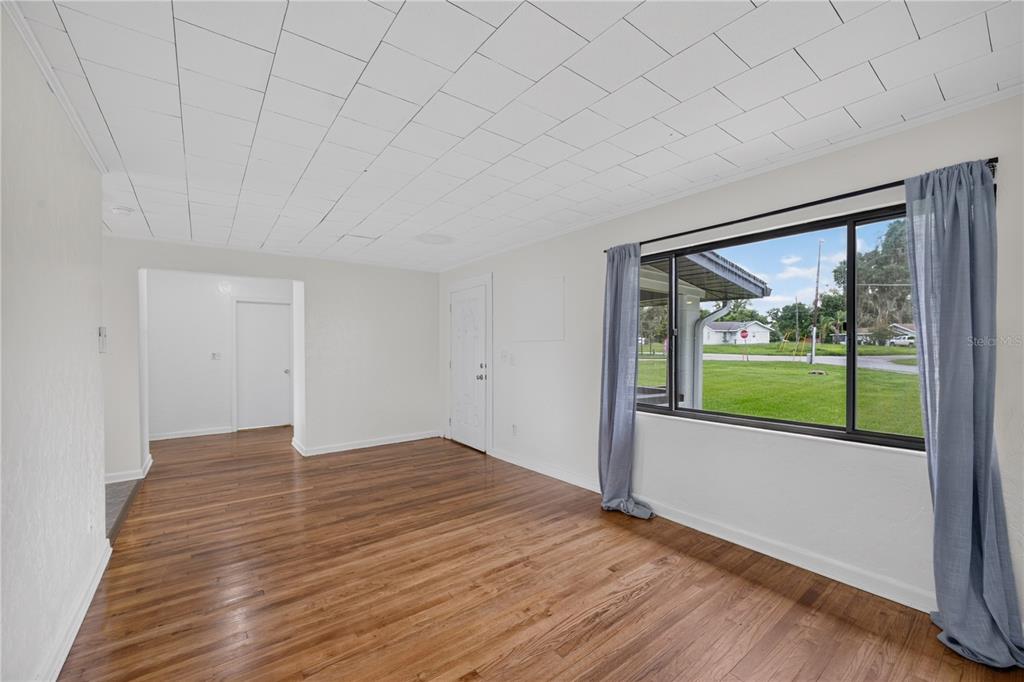 5514 Southeast Hames Road Belleview, FL 34420 - Photo 7 of 44 a view of an empty room with wooden floor and a window