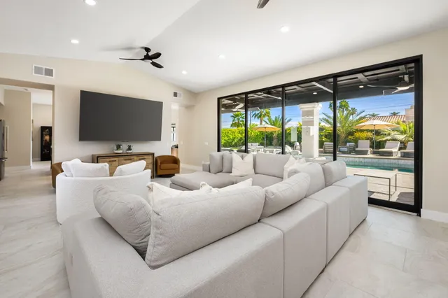 a living room with stainless steel appliances furniture and a large window