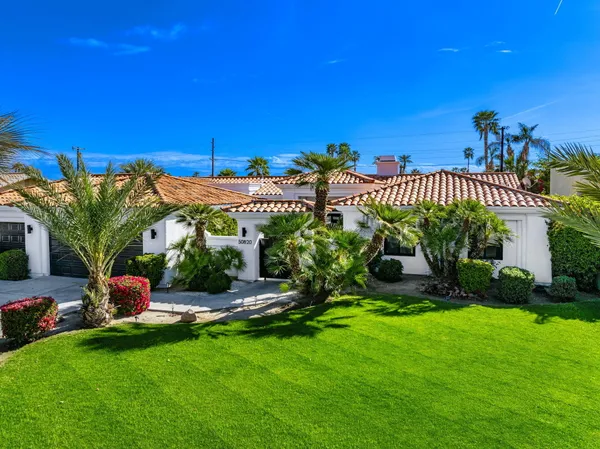 an aerial view of a house with a garden and lake view