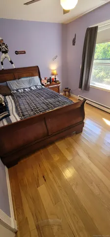 a bedroom with a bed and lamp on wall