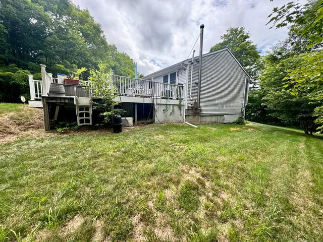 a view of a roof deck with table and chairs couches with wooden floor and fence