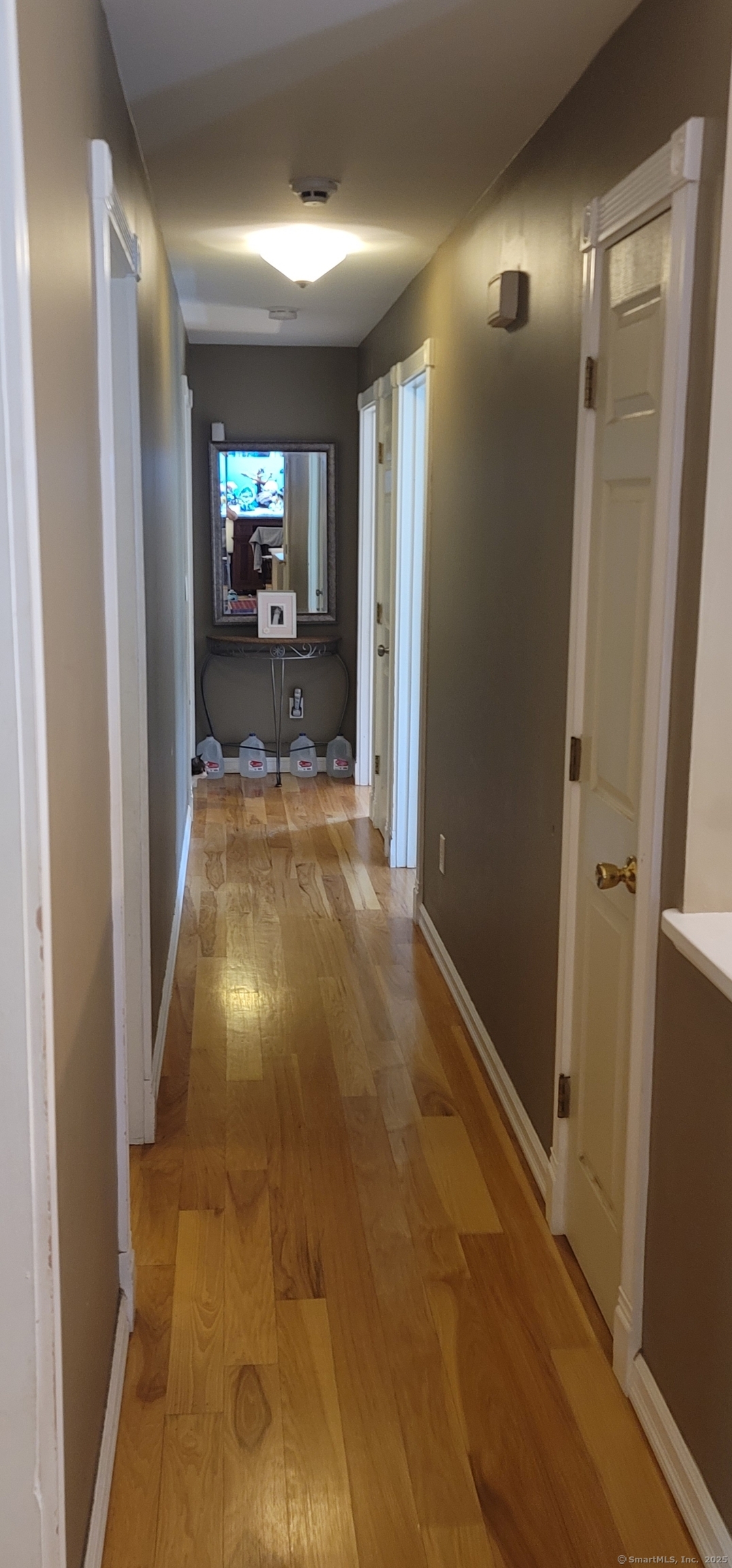 108 Webb Circle Monroe, CT 06468 - Photo 10 of 24 a view of a hallway with wooden floor and a living room