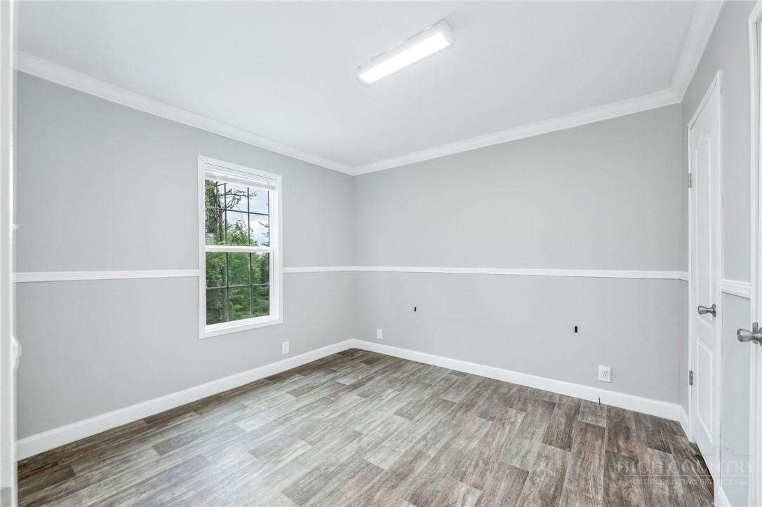 939 Don Bare Road Jefferson, NC 28640 - Photo 40 of 49 an empty room with wooden floor and window