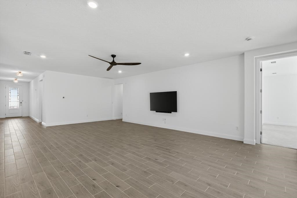 75776 Estuary Way Yulee, FL 32097 - Photo 11 of 83 an empty room with wooden floor and windows