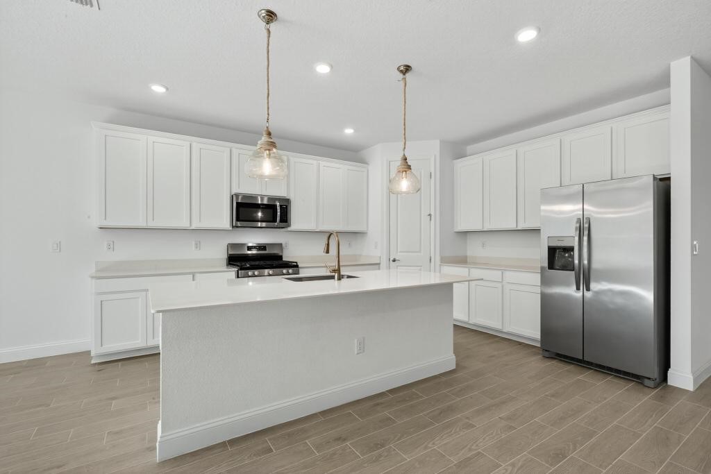 75776 Estuary Way Yulee, FL 32097 - Photo 14 of 83 a kitchen with stainless steel appliances granite countertop a refrigerator a sink a stove a microwave and white cabinets