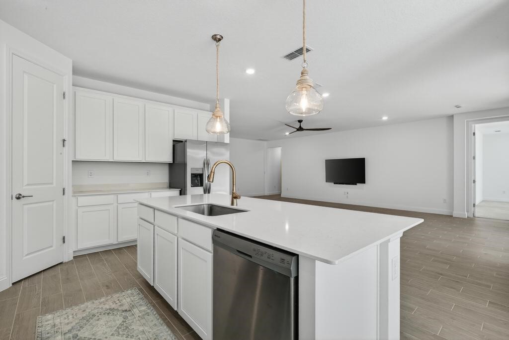75776 Estuary Way Yulee, FL 32097 - Photo 18 of 83 a kitchen with a sink dishwasher and white cabinets with wooden floor