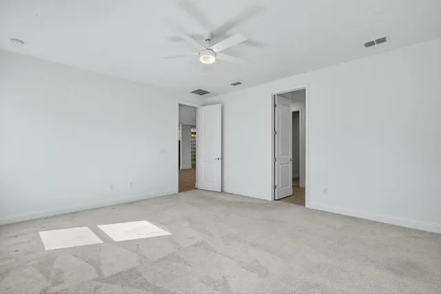 an empty room with a window and a fan