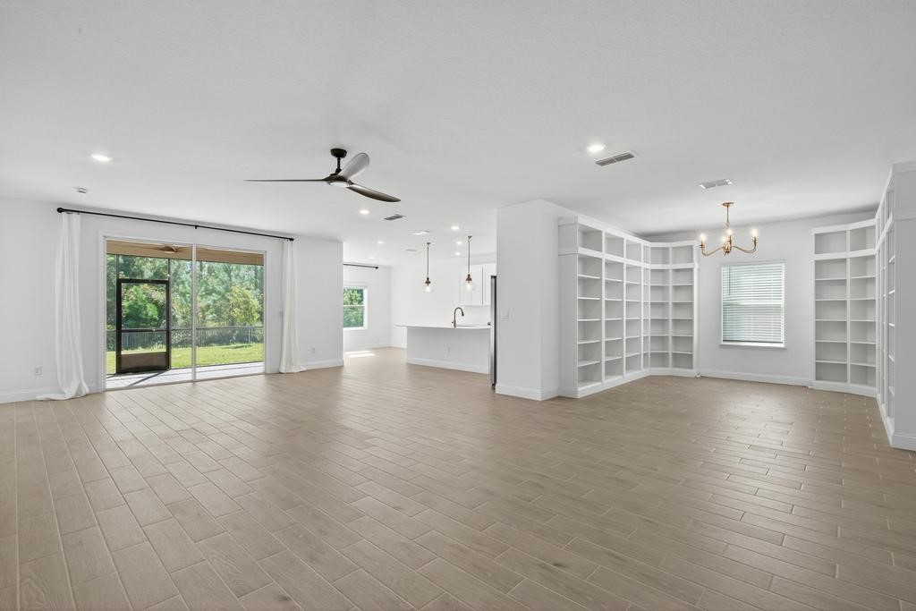75776 Estuary Way Yulee, FL 32097 - Photo 9 of 83 a view of an empty room with a window and wooden floor