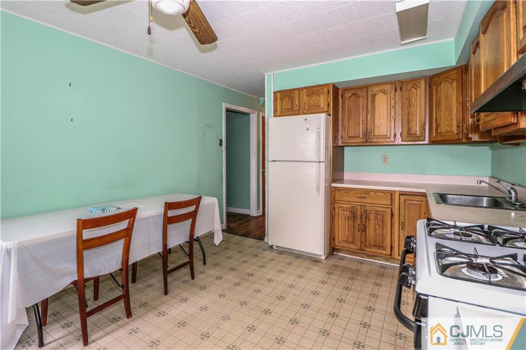 8 Kelly Street Metuchen, NJ 08840 - Photo 11 of 25 a kitchen with stainless steel appliances a stove top oven a refrigerator and a table