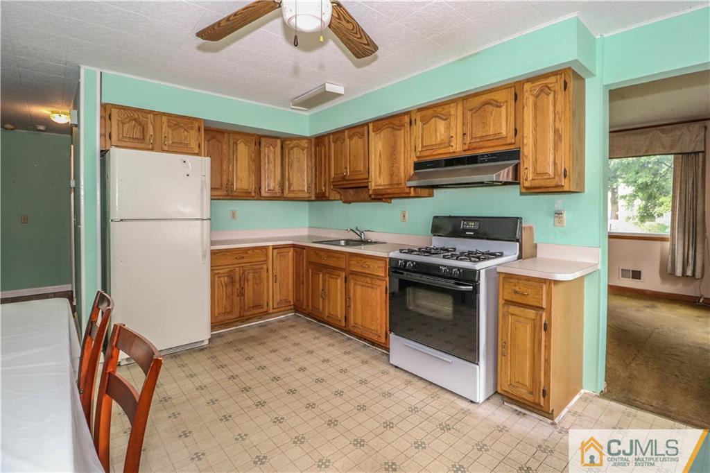 8 Kelly Street Metuchen, NJ 08840 - Photo 10 of 25 a kitchen with stainless steel appliances granite countertop a stove top oven a sink and a refrigerator