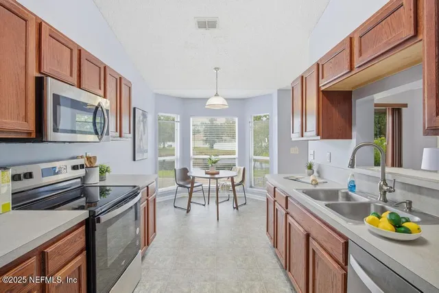 a kitchen with kitchen island granite countertop a sink stove and cabinets