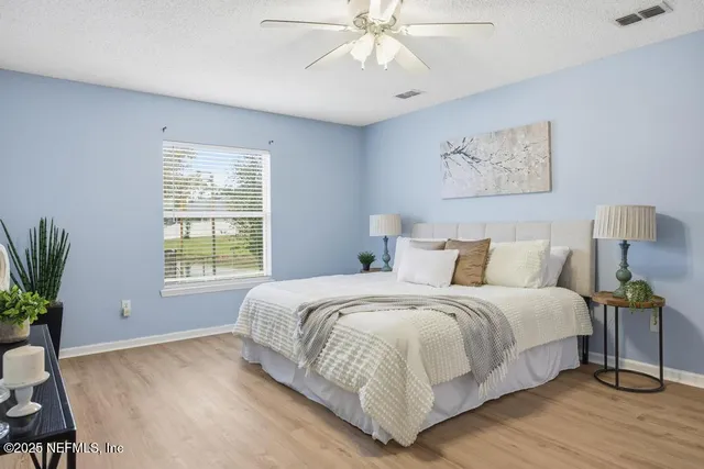 a bedroom with a large bed and a potted plant