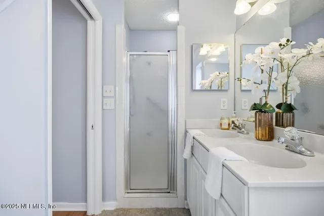 a bathroom with a sink vanity and shower