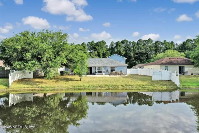 a view of swimming pool with outdoor seating and trees in the background