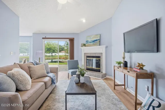 a living room with furniture a flat screen tv and a fireplace