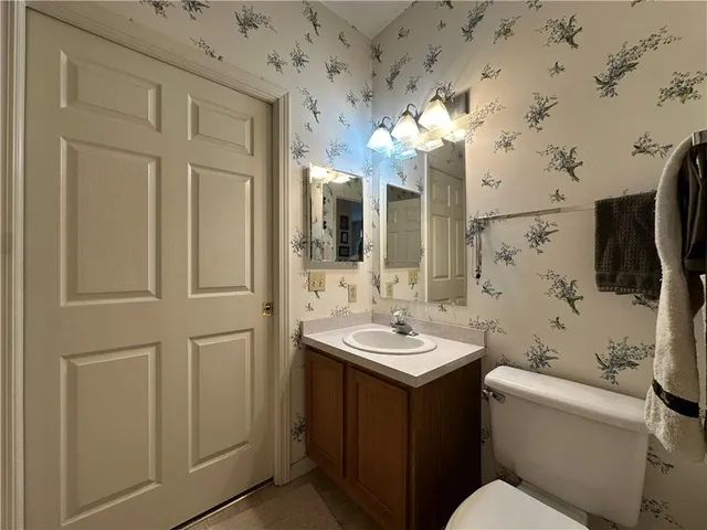 a bathroom with a toilet sink and mirror